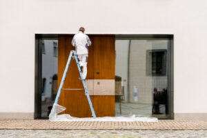 Man,On,A,Ladder,Painting,An,Apartment,Block,During,Exterior shutterstock 342064277